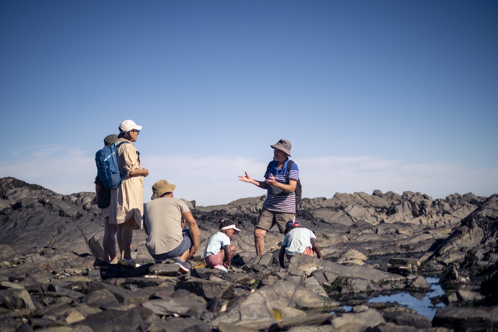 Charles Griffiths presenting to camera on the rocky shore